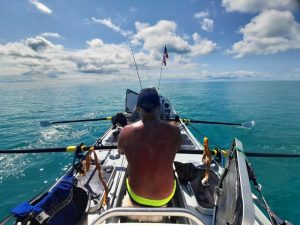 Silhouetted rower in turquoise water