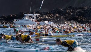 prone paddleboarders in an ocean race