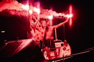 rowing crew with celebratory flares