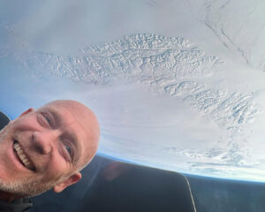 man in space with frozen view of Earth below