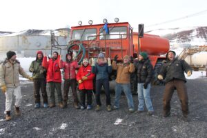people in funny candid poses in front of a big truck