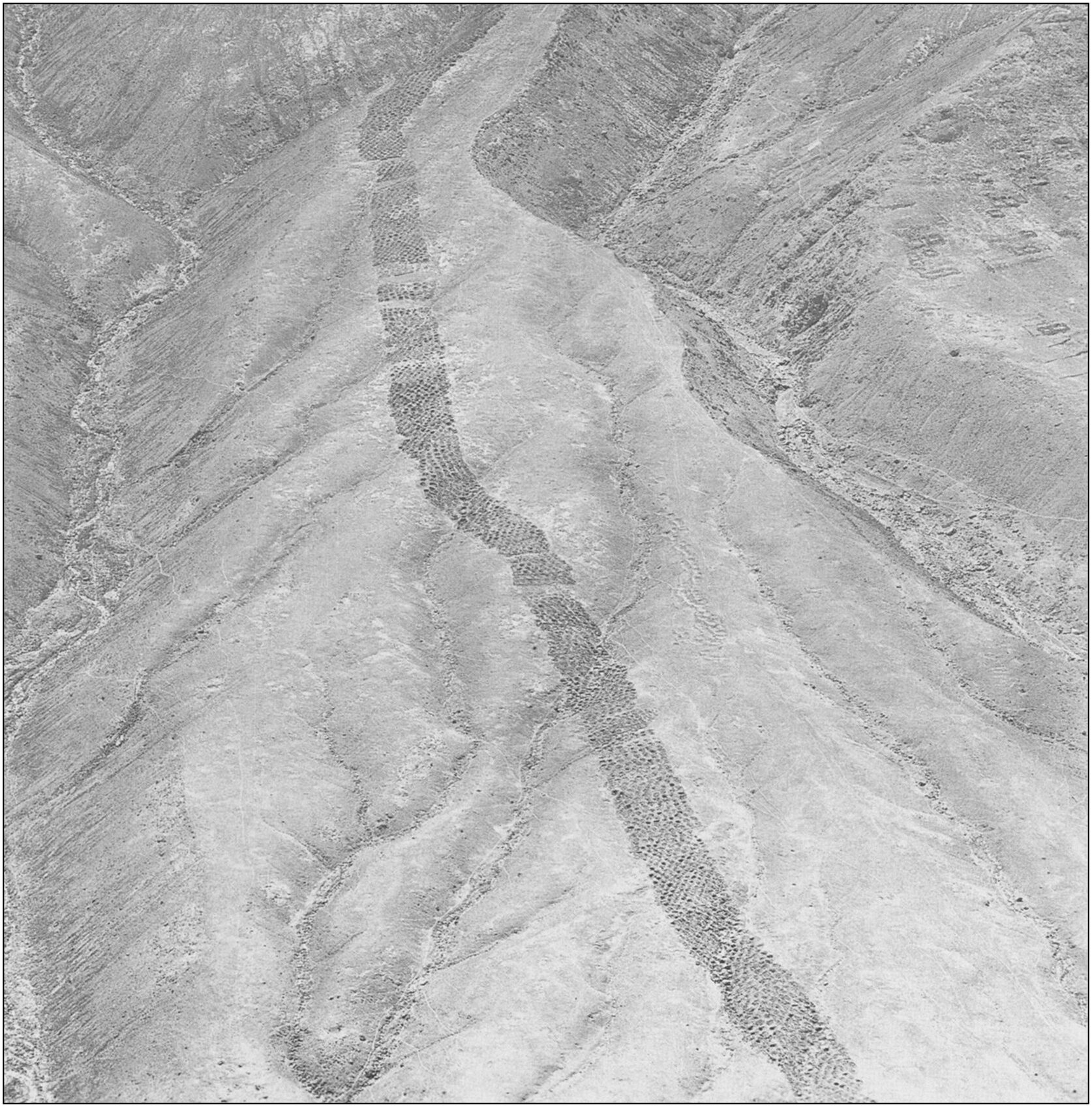 An aerial view of a long band of holes atop a mountain.