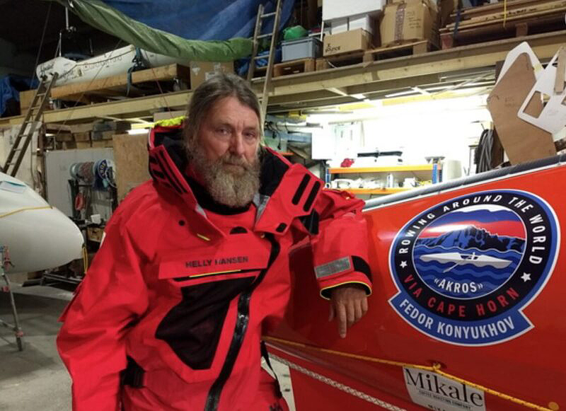 bearded guy beside rowboat on dry land