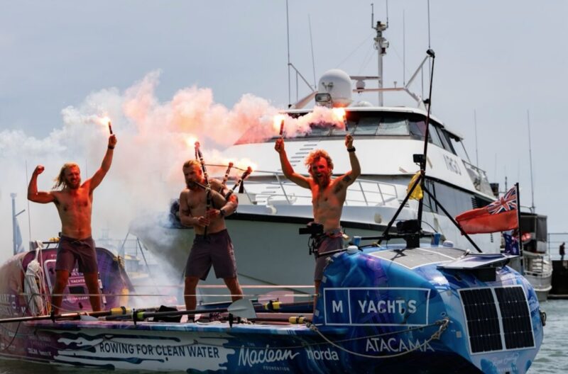 three guys with flares on rowboat in harbor
