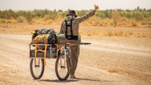 man in desert with supply cart.