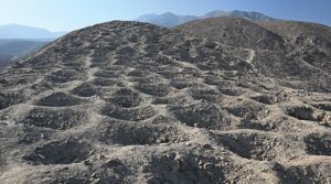 A close-up image of holes dug in dirt atop a mountain.