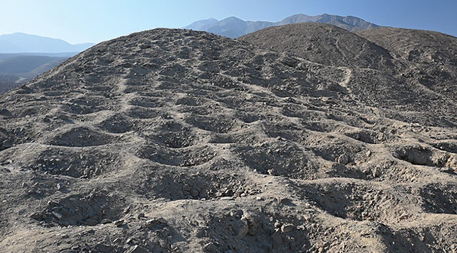 A close-up image of holes dug in dirt atop a mountain.