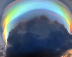 a rainbow halo around a thundercoud