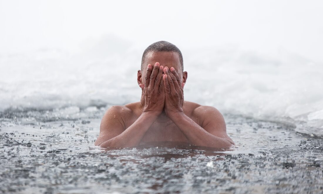 A man emerging from icy water.