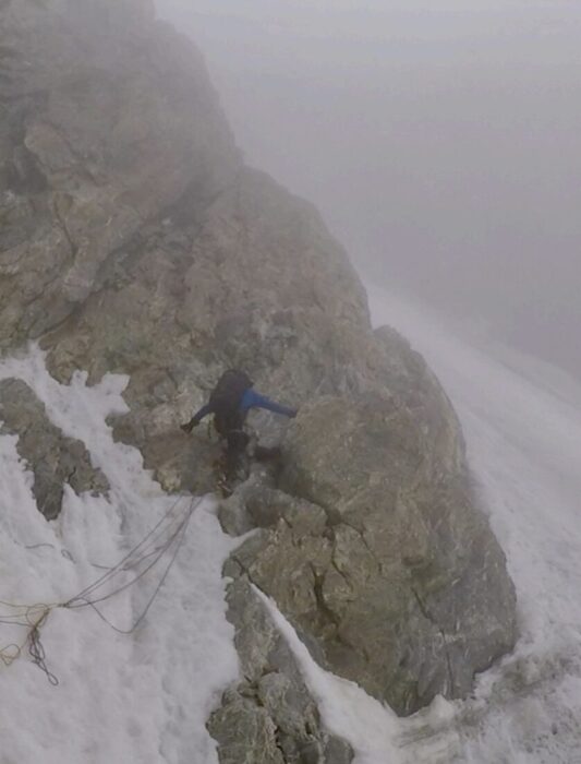 A climber on a rocky outcrop of a mixed c¡face in thick fog. 