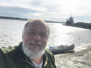 a man in front of a beached canoe