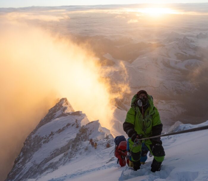 Two climbers at sunrise on the north side of Everest very close to the summit.
