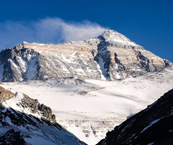 A wind plume rises from the summit of Everest, as seen from its north side.