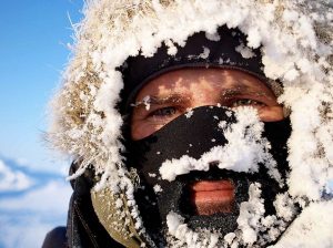 portrait of man with an iced up face mask and fur ruff