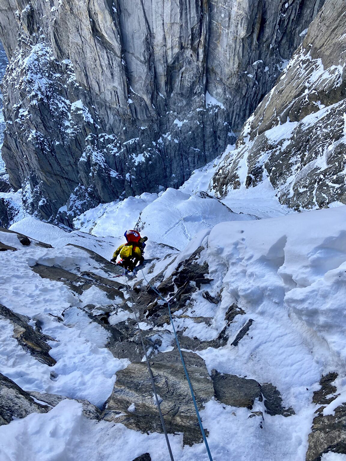 A climber on mixed terrain, very vertical and with the void at his feet.