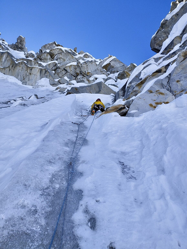 A climber on a vertical ice pitch.