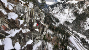 Two climbers in bright colored jackets on a mixed granite face.