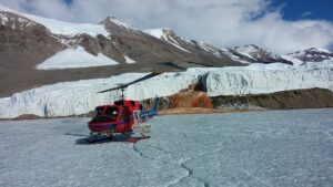 Red helicopter on a field of ice.