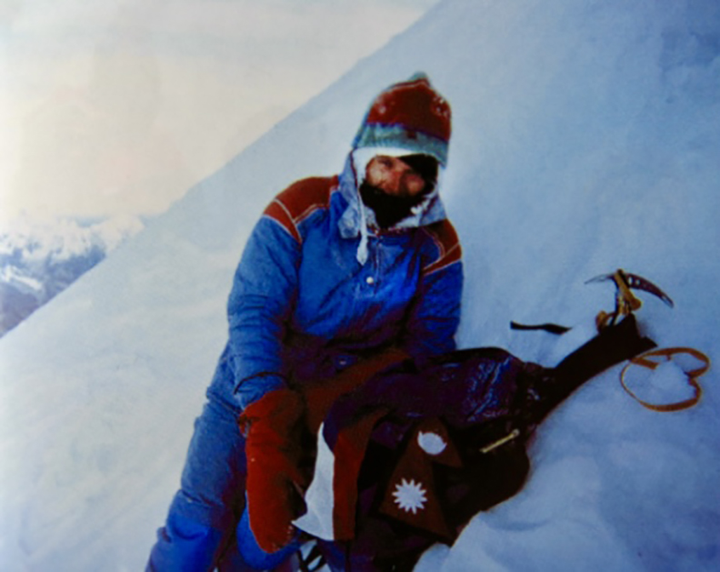 climber in blue down suit on slope