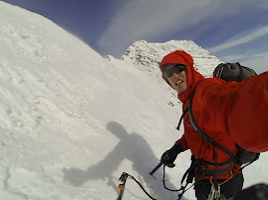 climber on snow slope in red jacket