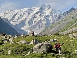line of hikers in a bouldery alpine meadow