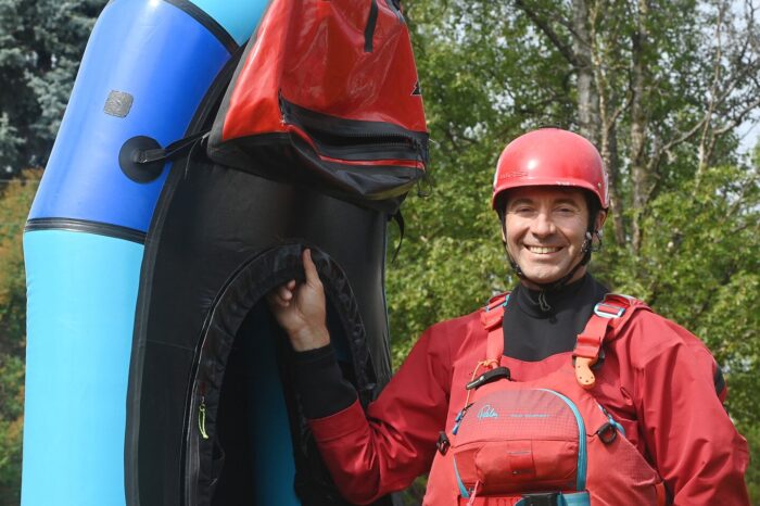 Packrafting educator Luc Mehl pictured holding up a packraft at his Anchorage home.