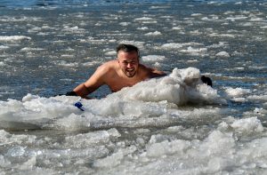 swimmier in icy water, clutching an ice floe