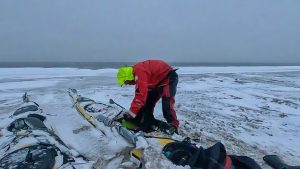 Mark Agnew tends to his kayak after a fall snowstorm.