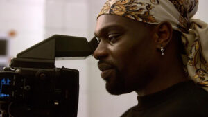 a man looking into the viewfinder of a video camera