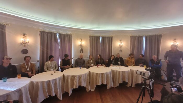 Climbers in a hotel hall with small tables in front. 