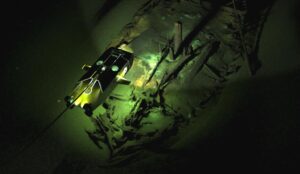 A shipwreck underwater with a small ROV