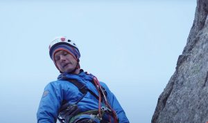 evgeniy glazunov looking down from near a mountain summit
