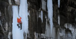 climber in orange on vertical ice
