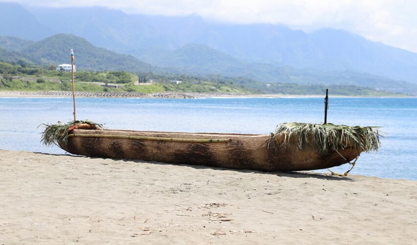 A dugout canoe on a beach.