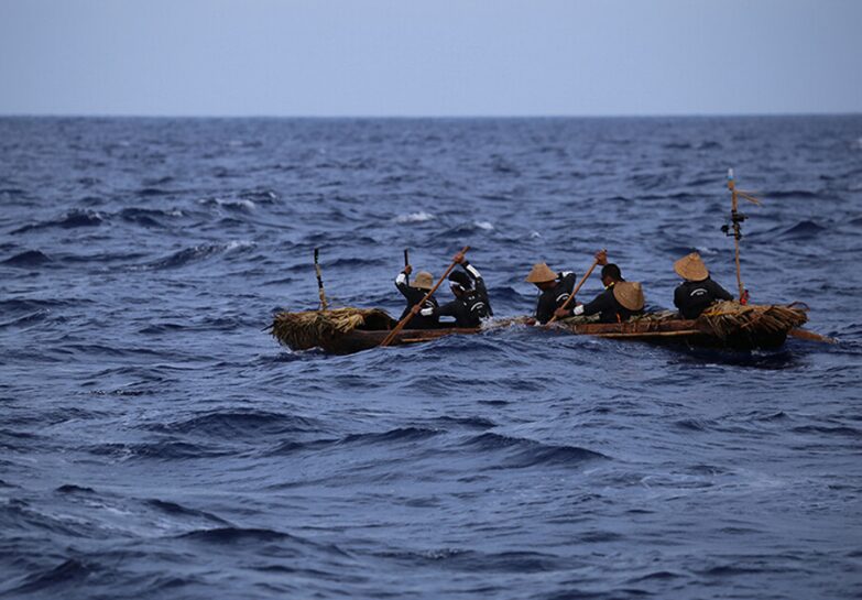 A canoe rowing against choppy waters.