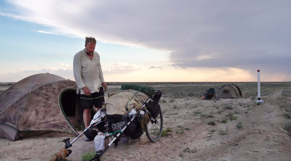 Bushby beside tent and cart in desert