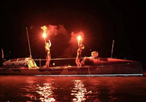rowers light flares at night