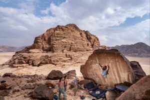 Lewis Perrin climbing on the Dajaj Aady boulder (7a), in the Shegeag sector of Wadi Rum.