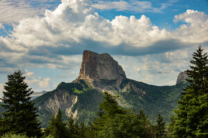 a picturesque pillar of rock below a partly cloudy sky