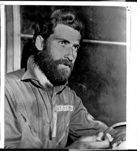 David Steeves seated. He is simply dressed and has a large beard.