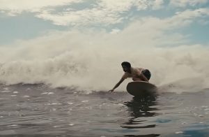 Black surfer catching a wave