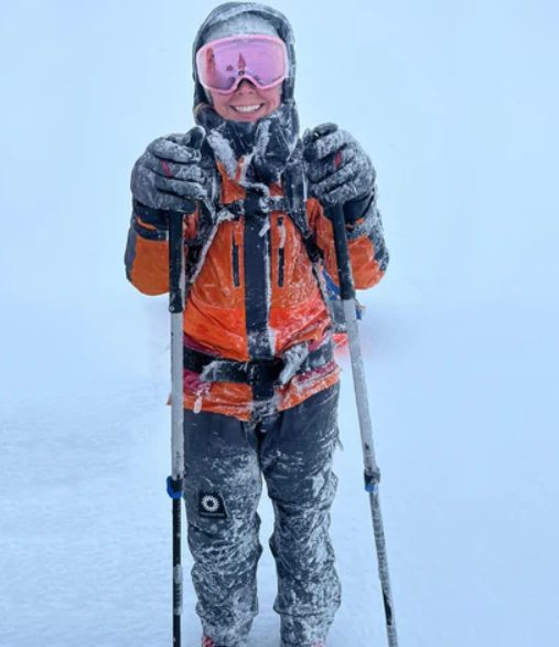 Wendy Searle covered in snow and ice, wearing skis in near white-out conditions