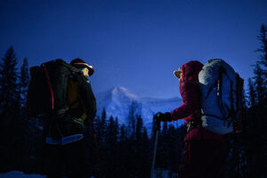 The climbers at dawn, with headlamps on, approaching a mountain.