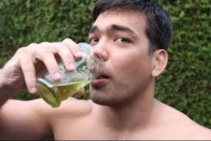 Man drinking urine from a glass